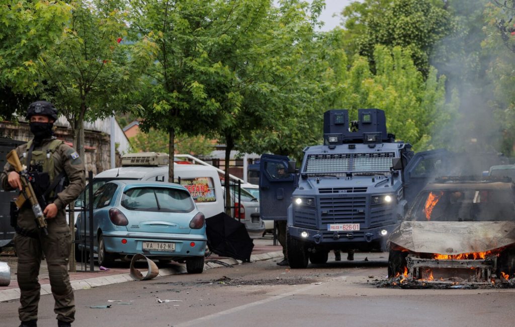 Pripadnici specijalne policije stoje pored zapaljenog automobila, nakon sukoba policije i grupe građana iz srpske zajednice, koji su pokušali da spreče novoizabranog gradonačelnika da uđe u kancelariju, u Zvečanu (Foto Rojters)