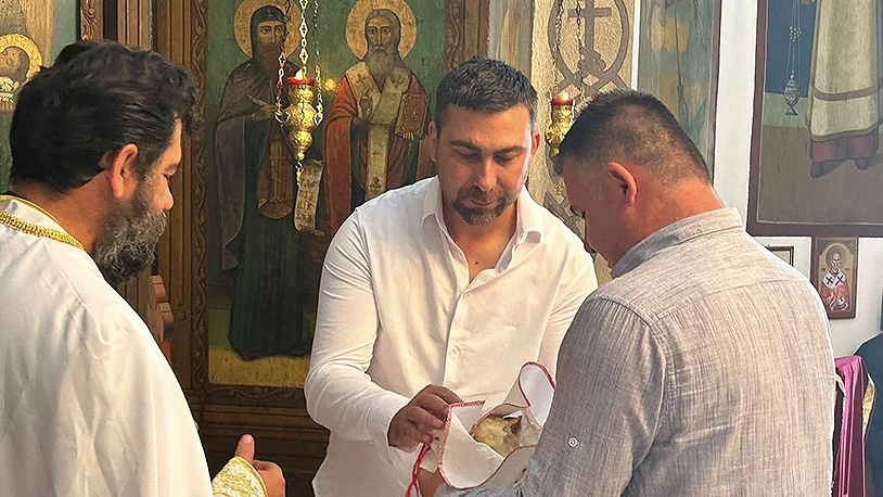 Milovan Milanković, domaćin slave deli kolač narednom kolačaru (Foto Kim)